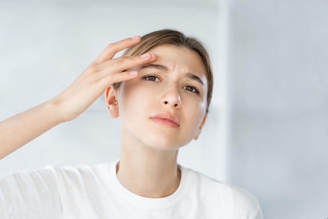 sensitive skin acne problem woman touching face
